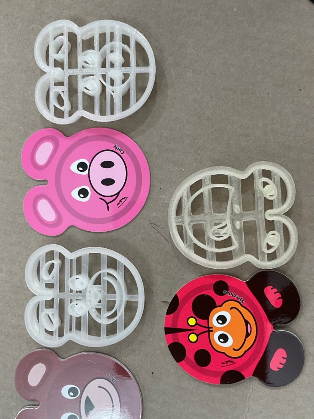 3 animal face shaped sandwich cutters with accompanying animals shaped coasters